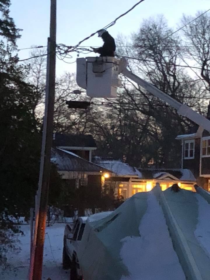 A man in a bucket is working on a power line