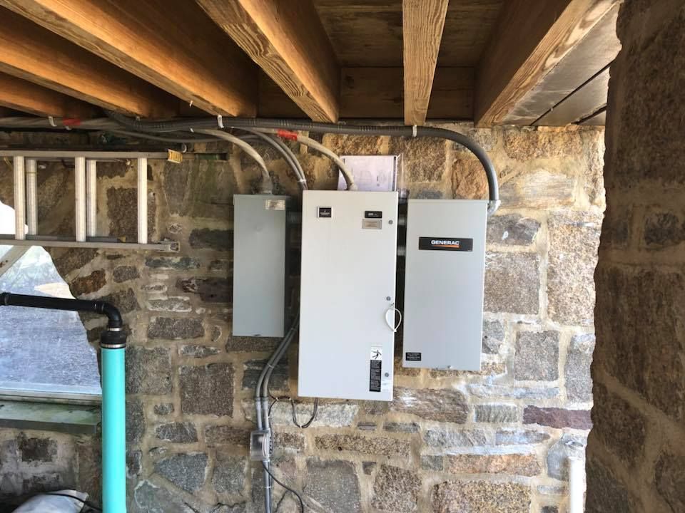 A brick wall with a ladder and electrical boxes on it