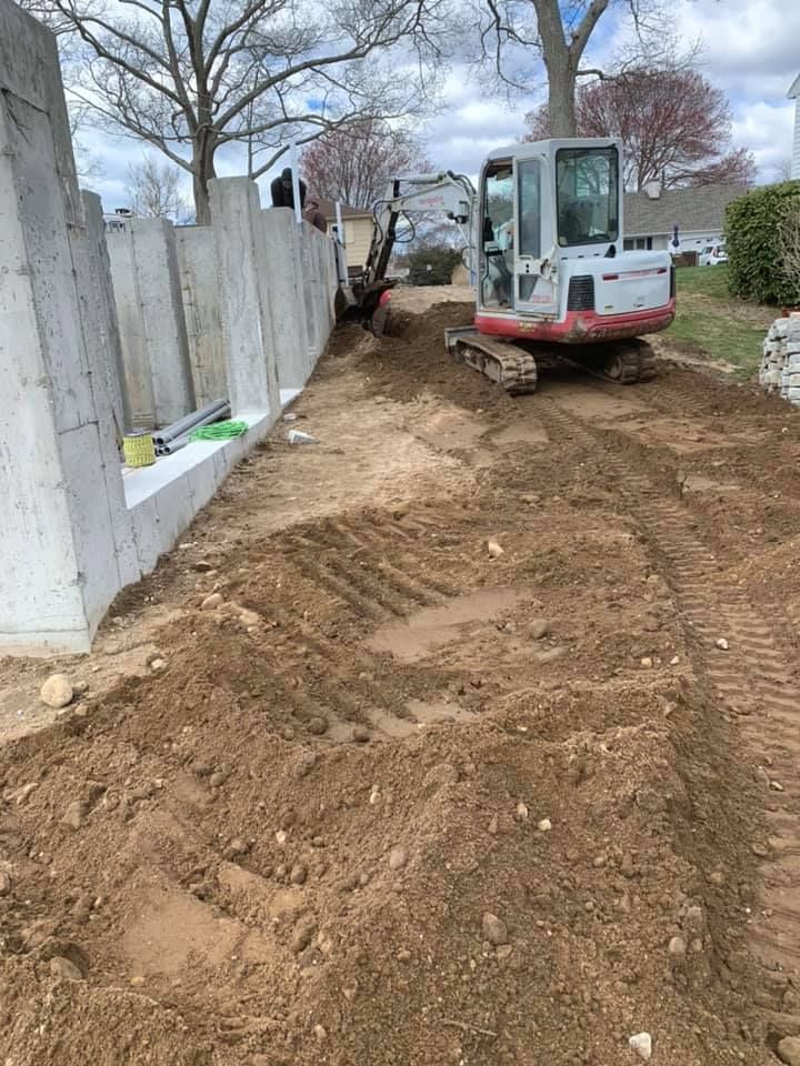A small excavator is driving down a dirt road.