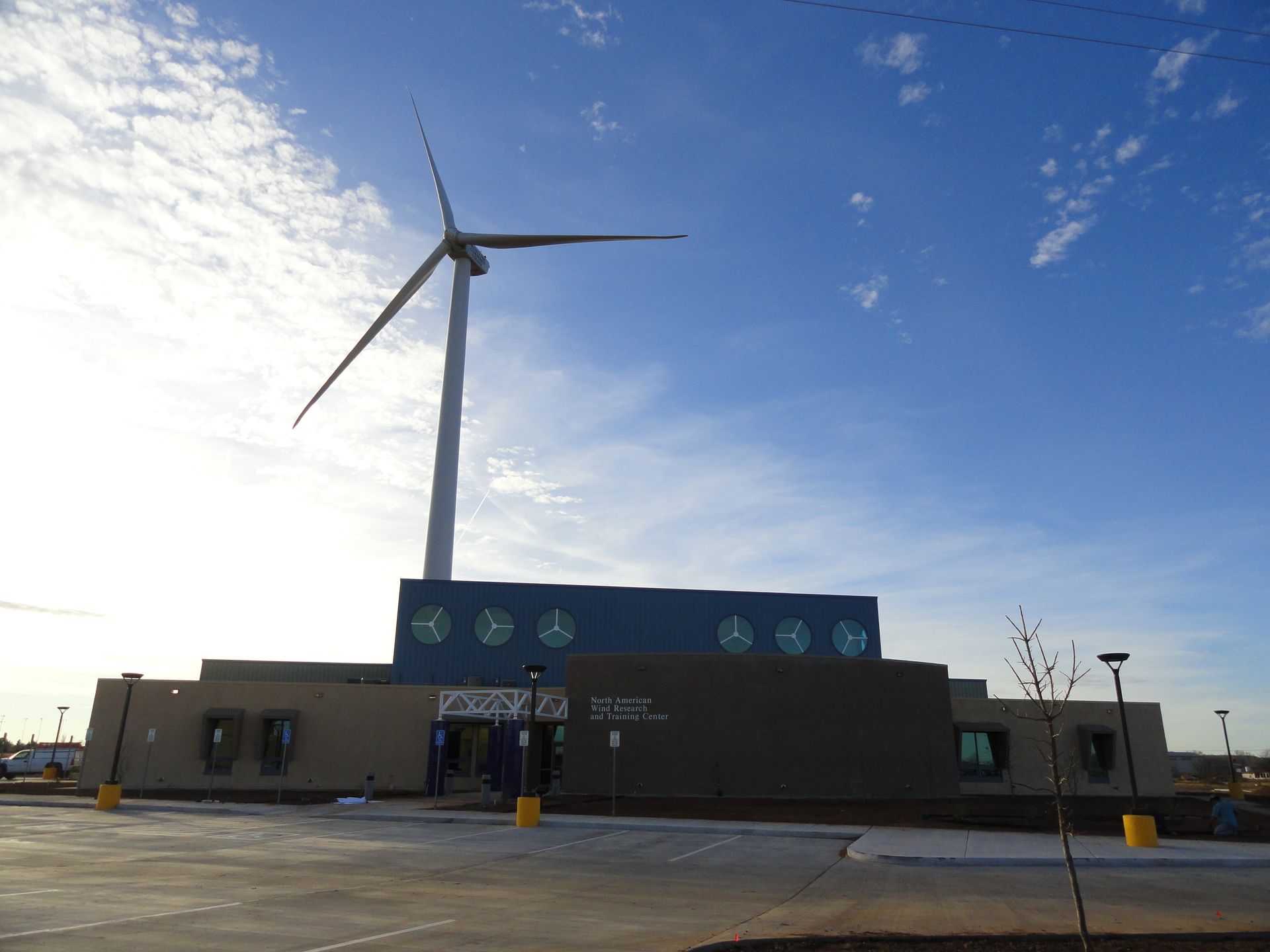 A large wind turbine is in front of a building