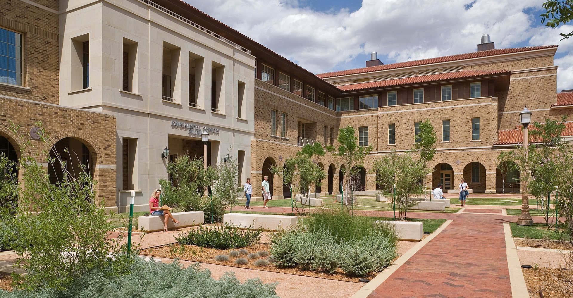 A large building with a brick walkway leading to it.
