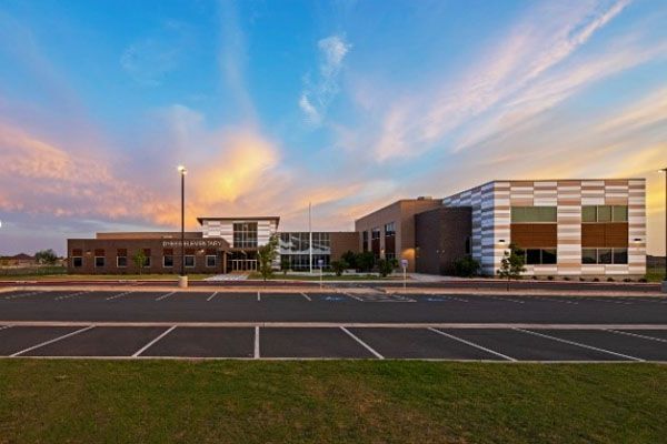 A large building with a parking lot in front of it.