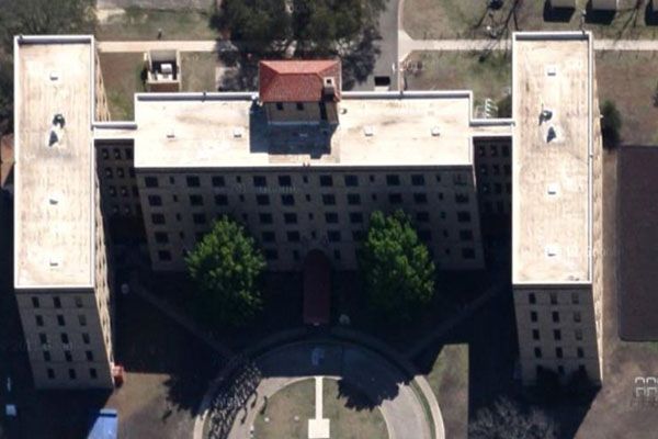 An aerial view of a large building with a red roof