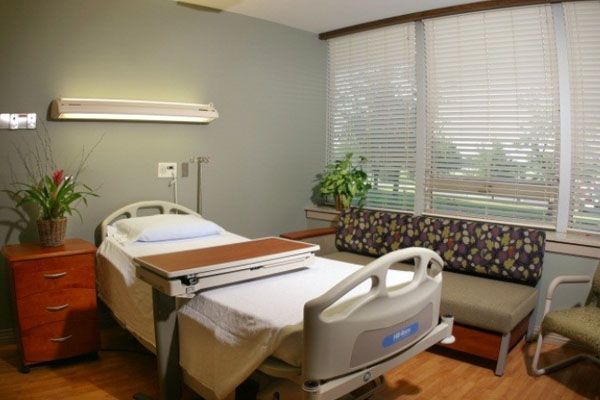 A hospital room with a bed and a couch