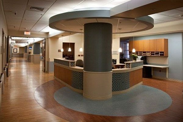 A hospital hallway with a reception desk in the middle
