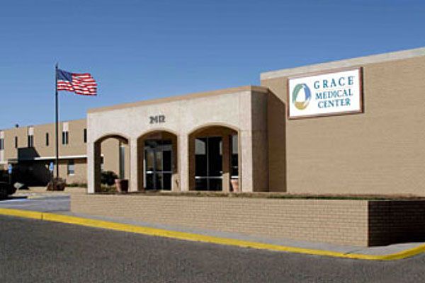 A grace medical center building with an american flag in front of it