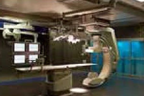 A hospital room with a surgical table and a ct scan machine.