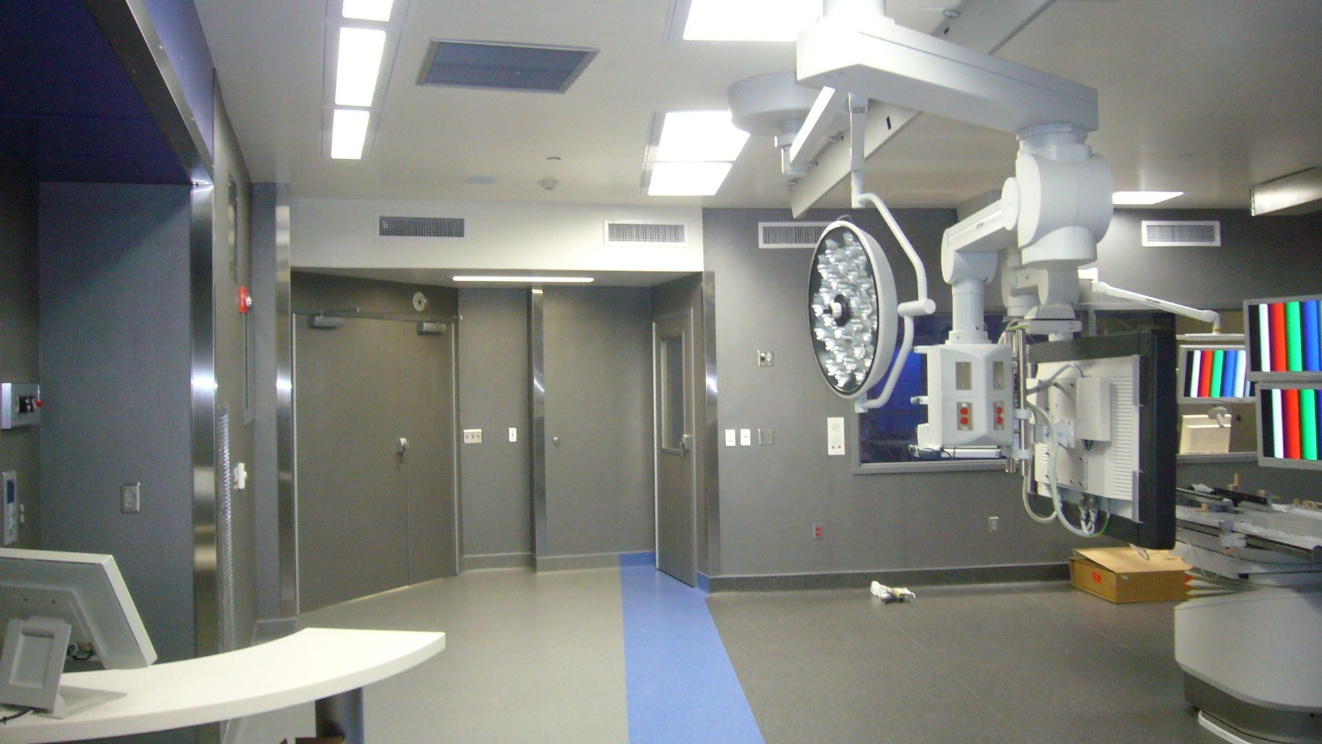 An empty operating room with a blue stripe on the floor