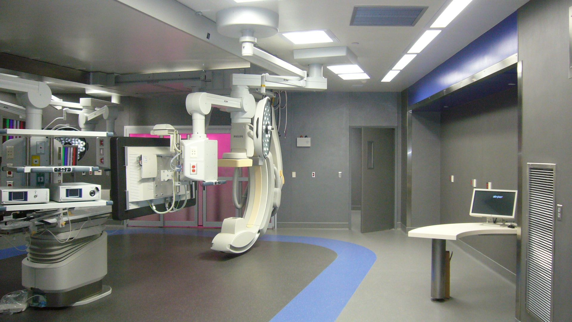 An empty operating room with a blue stripe on the floor