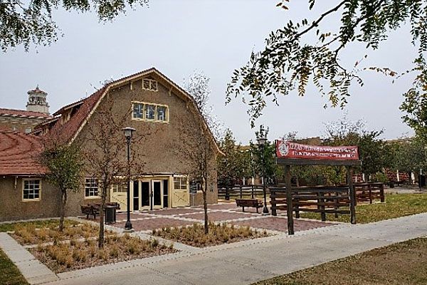 A large barn with a red roof and a sign in front of it.