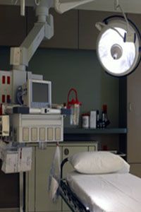 An operating room with a bed and a monitor