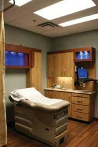 A doctor 's office with a bed and cabinets