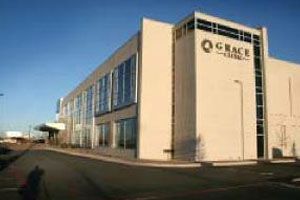 A large white building with a lot of windows and a blue sky in the background.