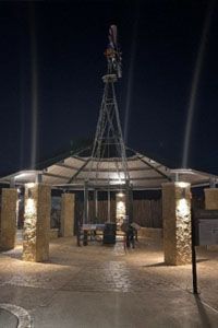 A gazebo with a windmill on top of it at night.