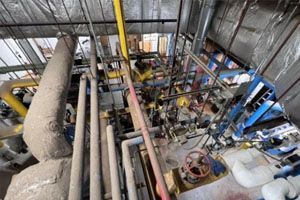 A bunch of pipes are hanging from the ceiling of a building.