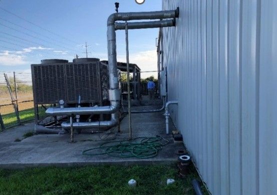 A large white building with a lot of pipes coming out of it.