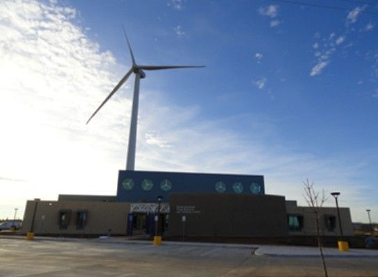 A large wind turbine is in front of a building