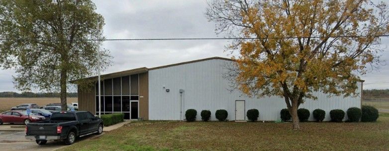 A white building with a truck parked in front of it.