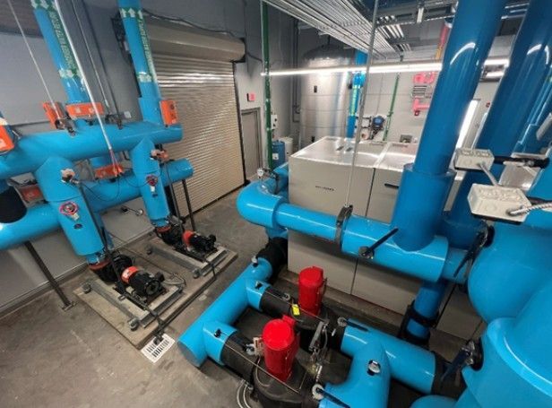A room filled with lots of blue pipes and pumps