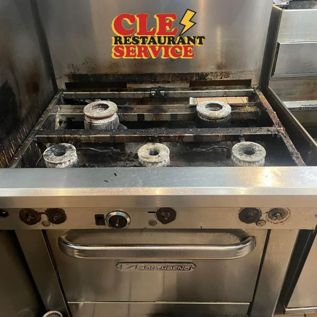 Stainless steel commercial stove with five gas burners.