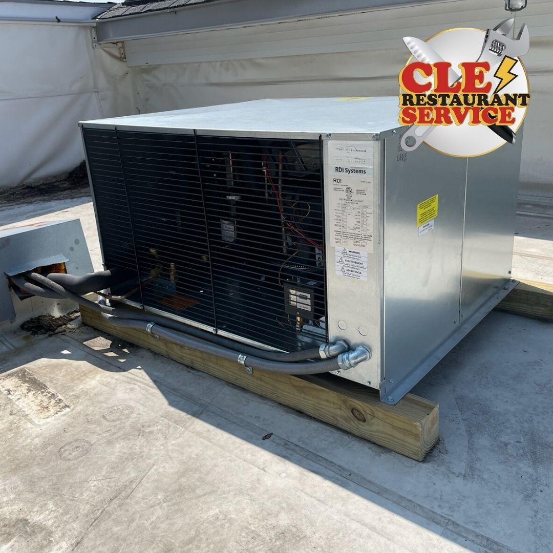 A commercial rooftop AC unit on wooden beams with the logo 