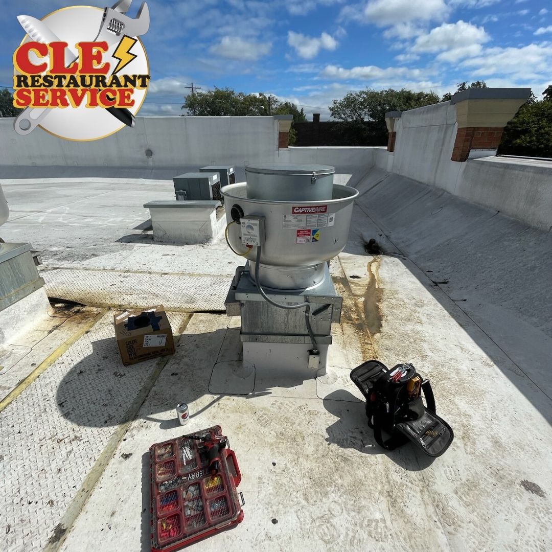 A commercial rooftop with a fan, tools, and a logo for restaurant service.