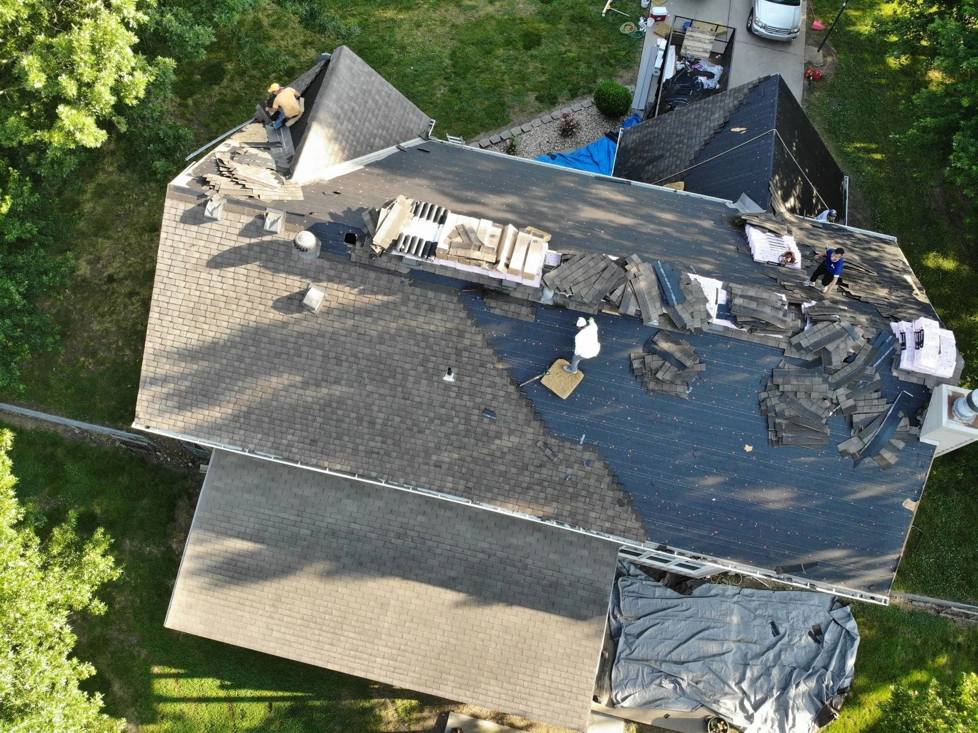 Aerial view of house roof with exposed areas undergoing repair.