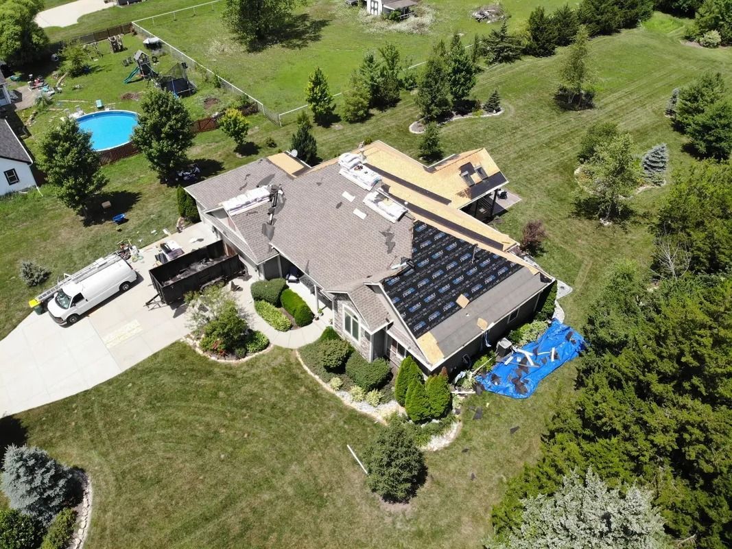 Aerial view of a house with solar panels being installed on the roof.