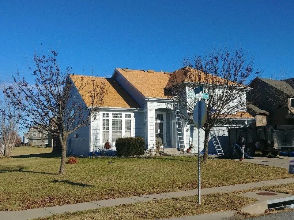 House with partially replaced roof, ladder, and construction in progress.