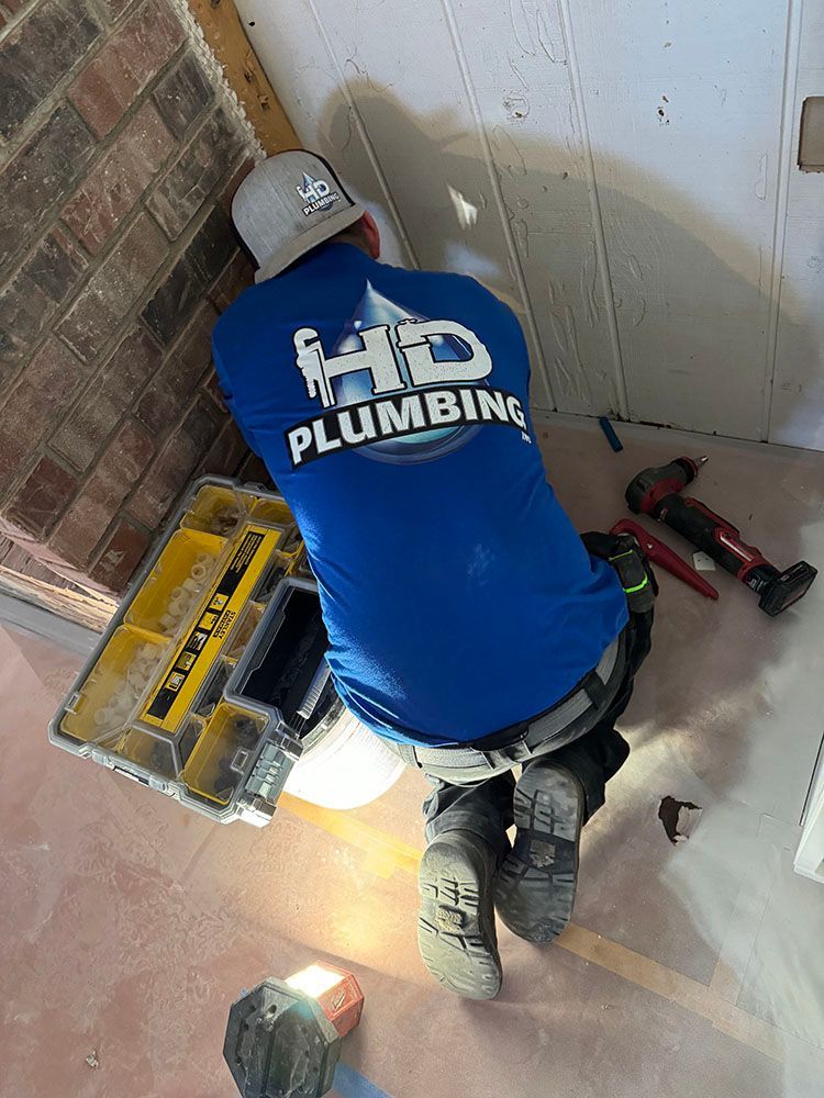 A man in a blue shirt is kneeling down in a room.
