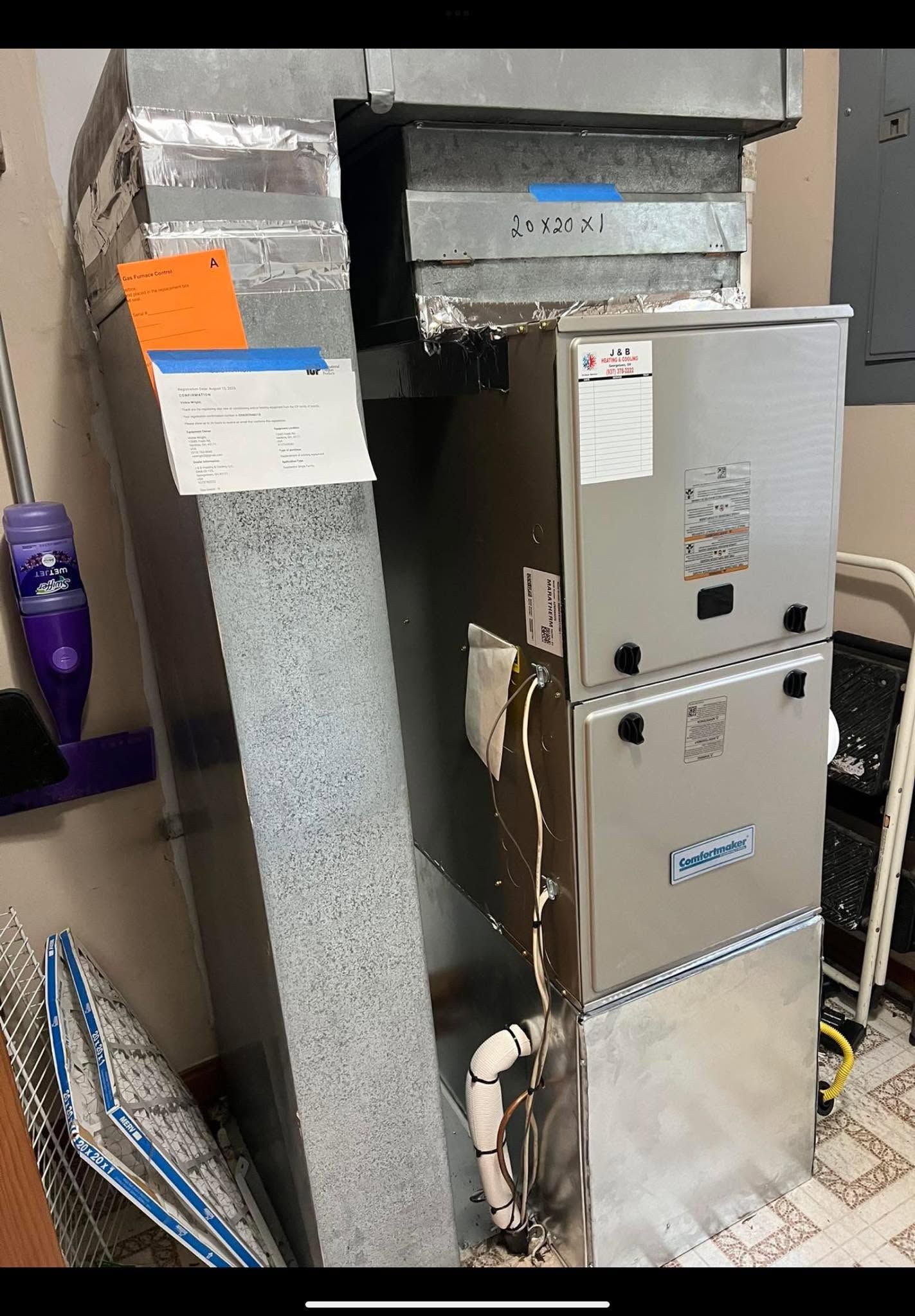 Commercial HVAC ductwork and metal air handling unit in a mechanical room.