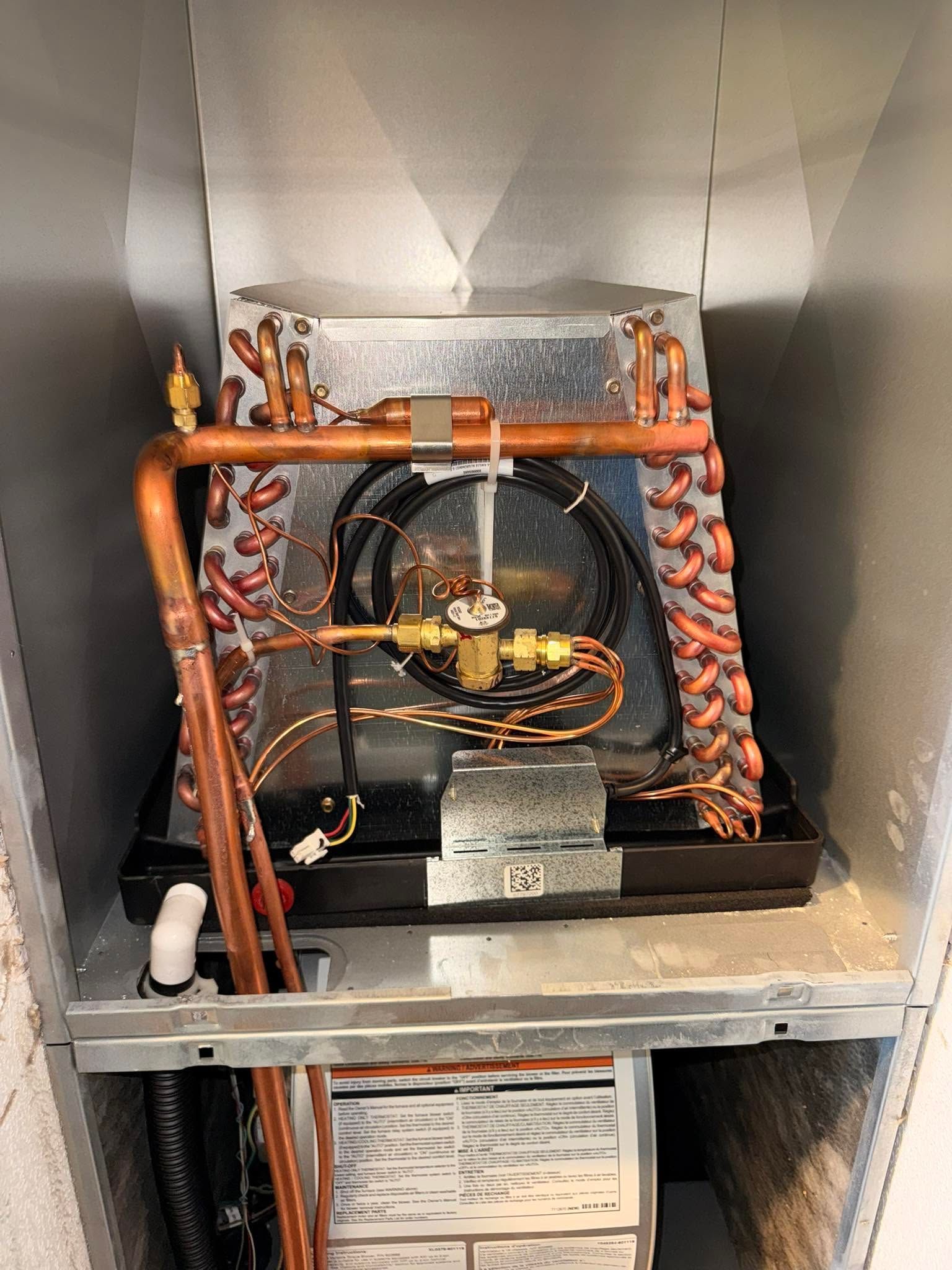 A small mechanical display with a fan and copper tubing inside a metallic cabinet.