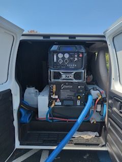 White van interior with carpet cleaning equipment.