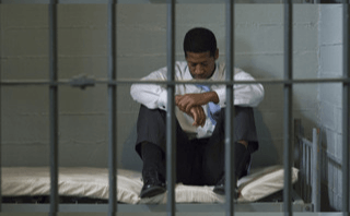 man-sitting-in-jail