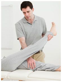 A therapist massaging patient’s leg