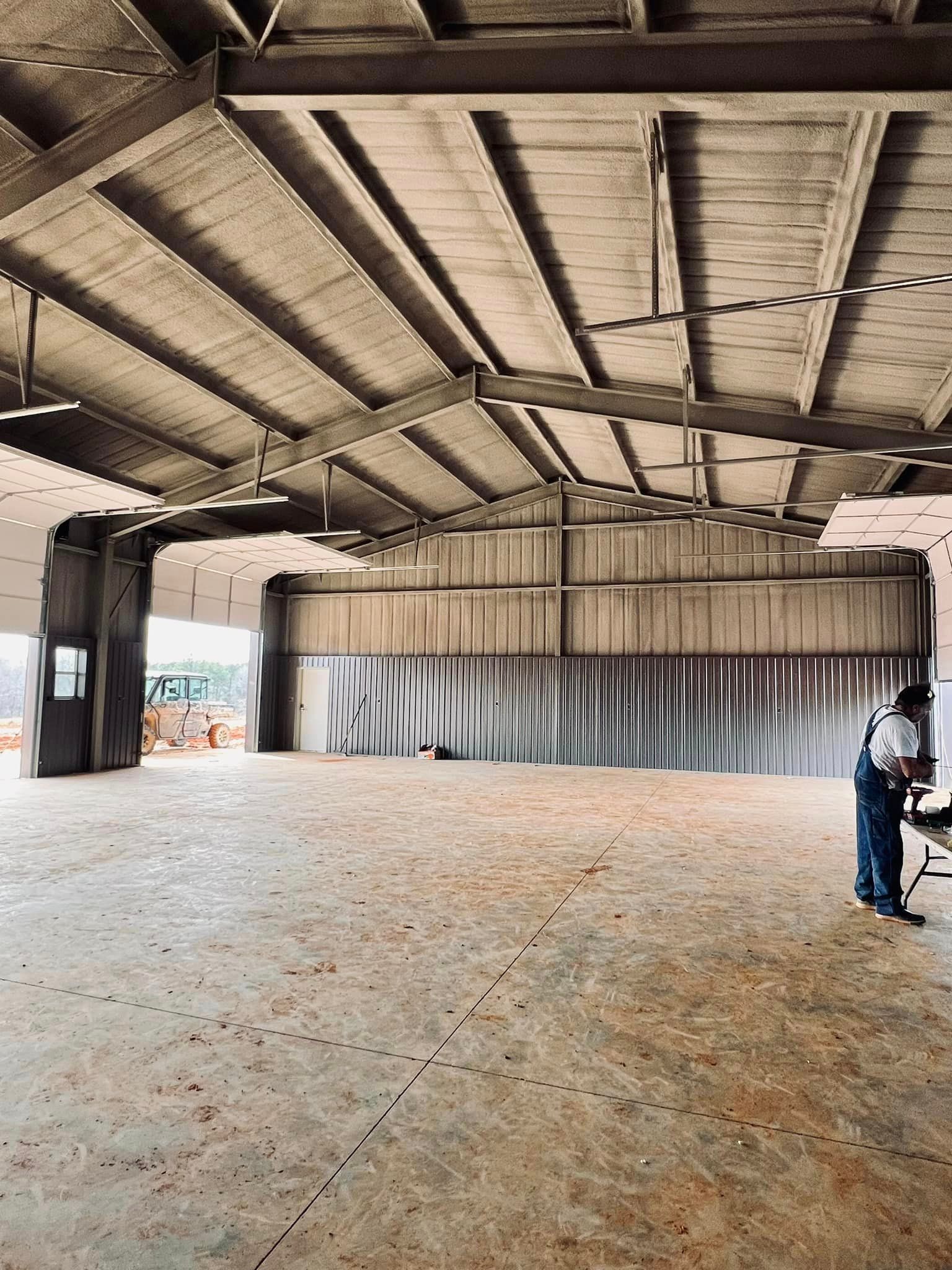 a man is standing in a large empty warehouse .