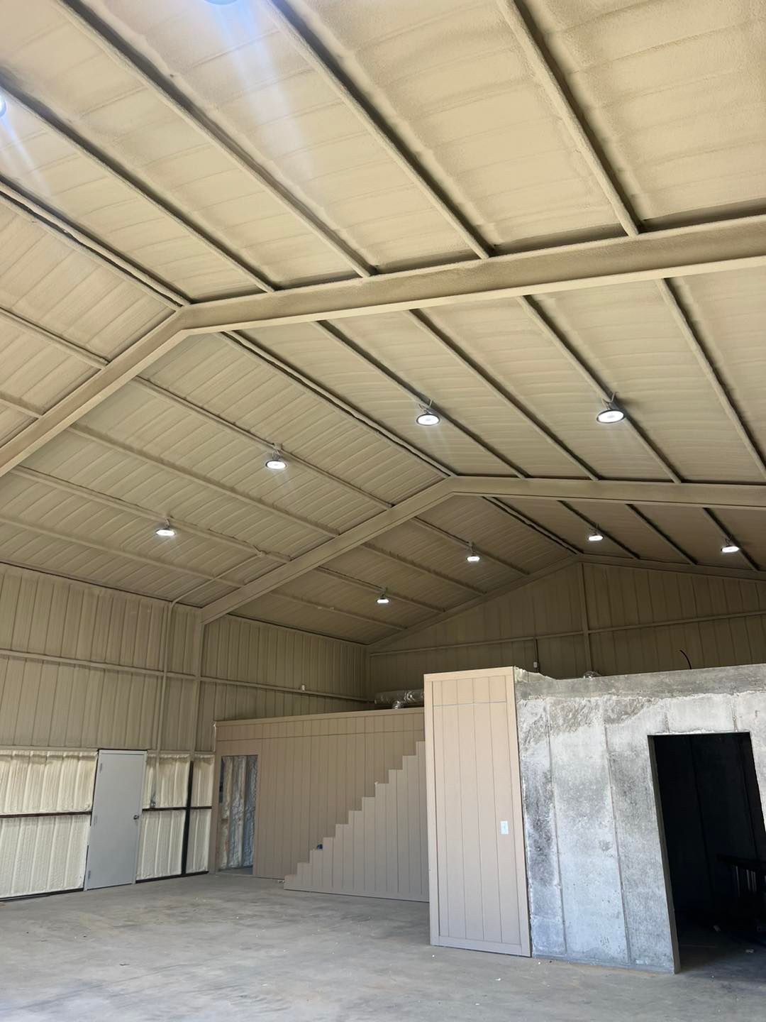 a large warehouse with a staircase leading up to the second floor .