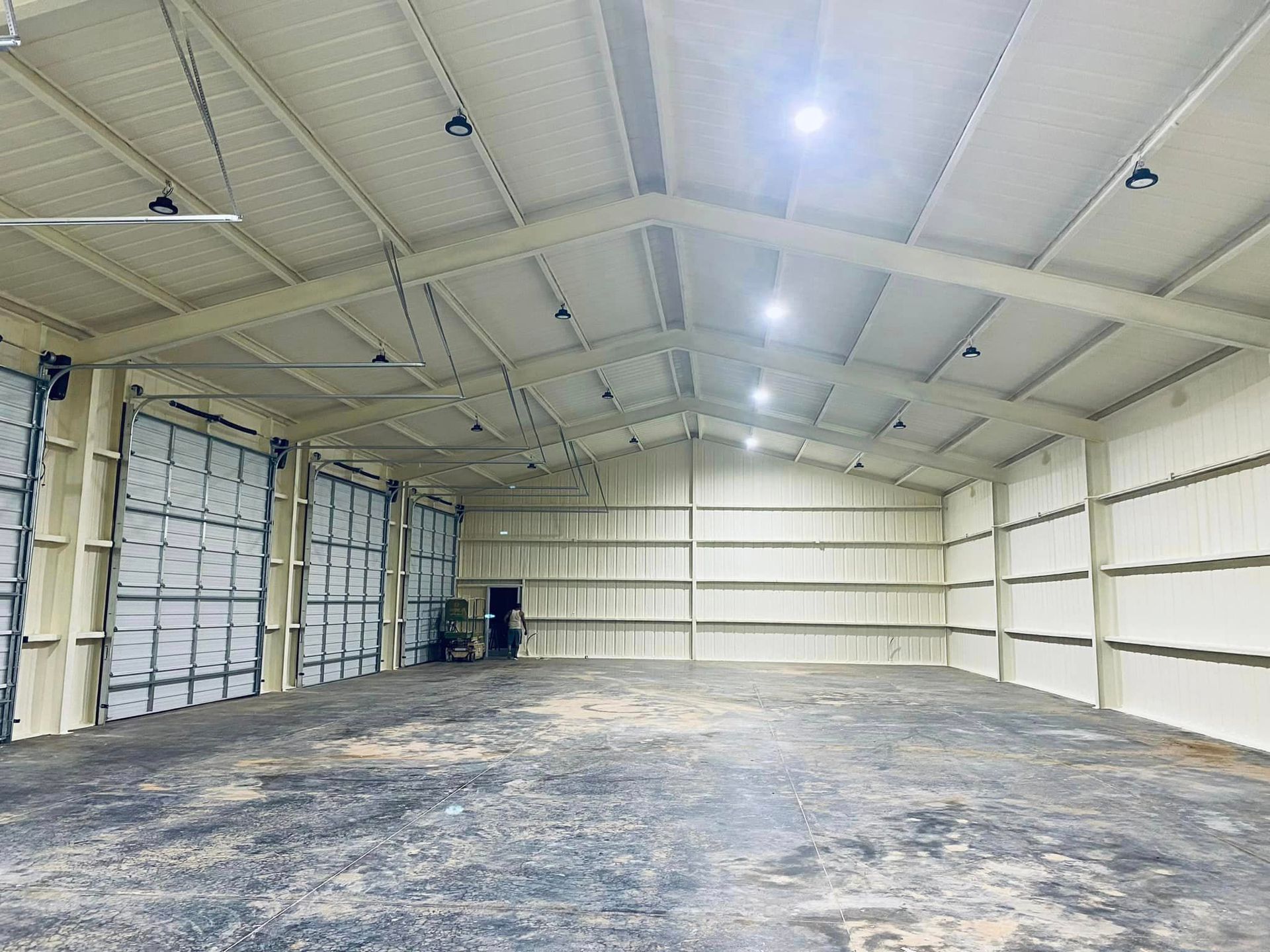 a large empty warehouse with a lot of doors and lights on the ceiling .