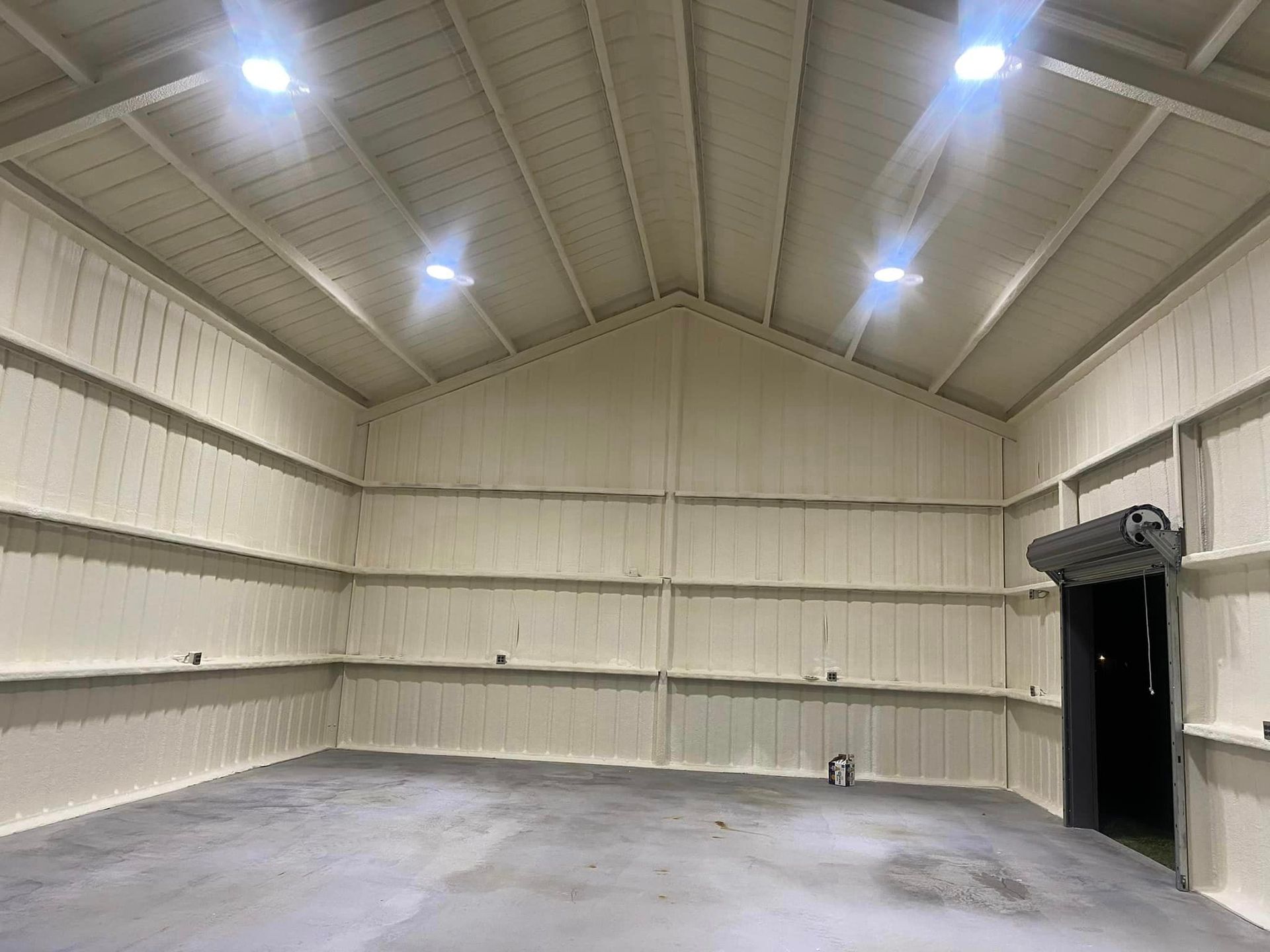 a large empty warehouse with white walls and a concrete floor .