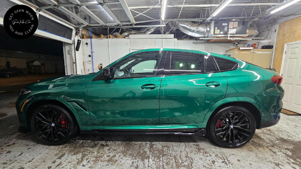 Green SUV parked in a garage; black wheels, red brake calipers.