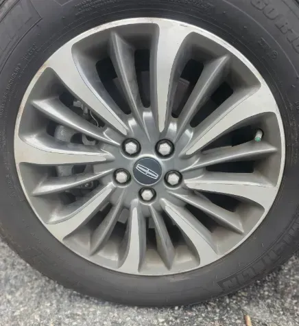 A close-up of a Lincoln vehicle wheel with a multi-spoke, silver and gray alloy rim, featuring the brand's logo.
