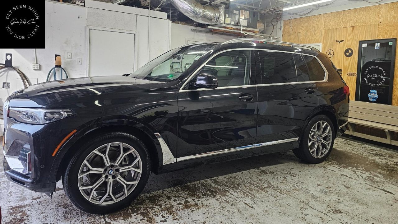 Black SUV parked inside a garage. The vehicle has chrome wheels and trim.