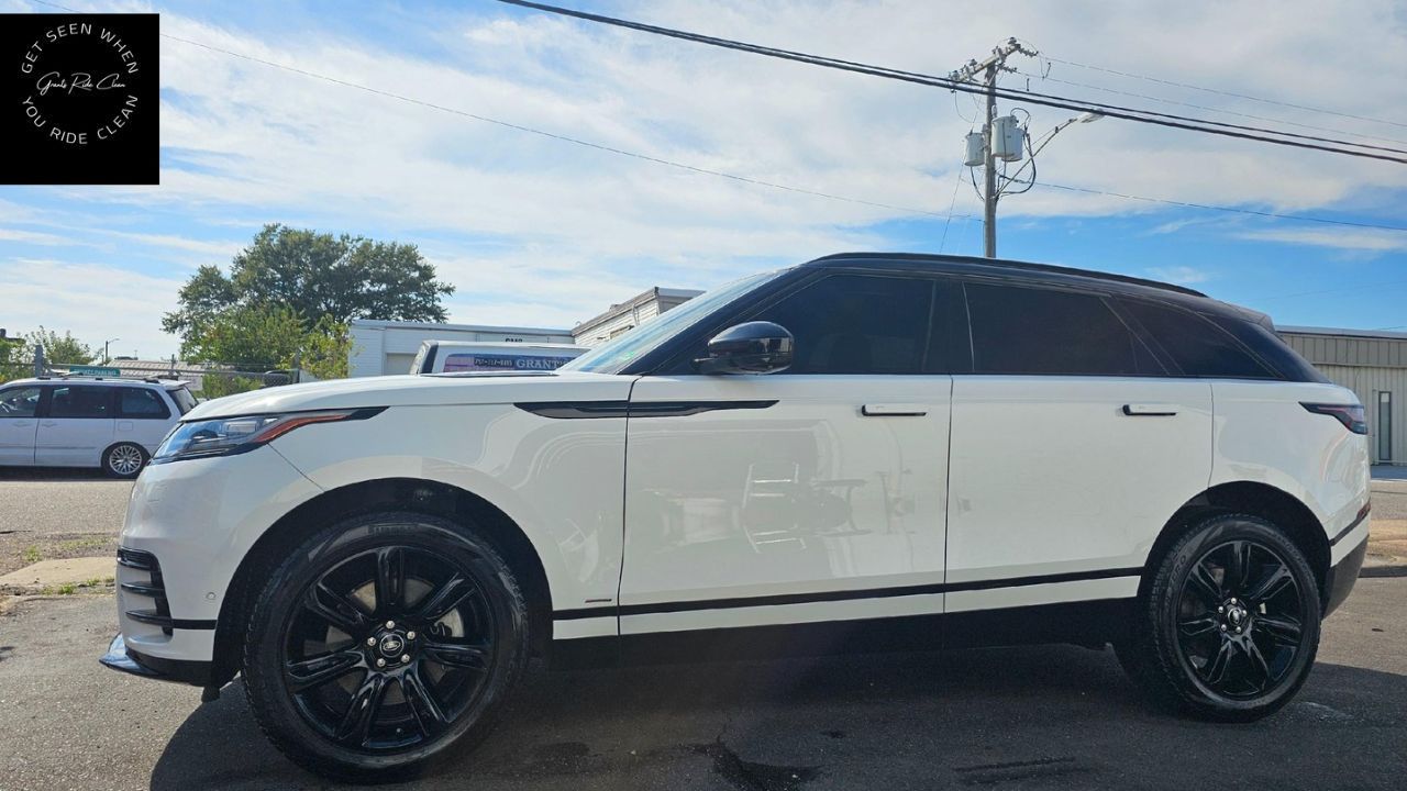 White Range Rover SUV with black rims parked outdoors under a partly cloudy sky.