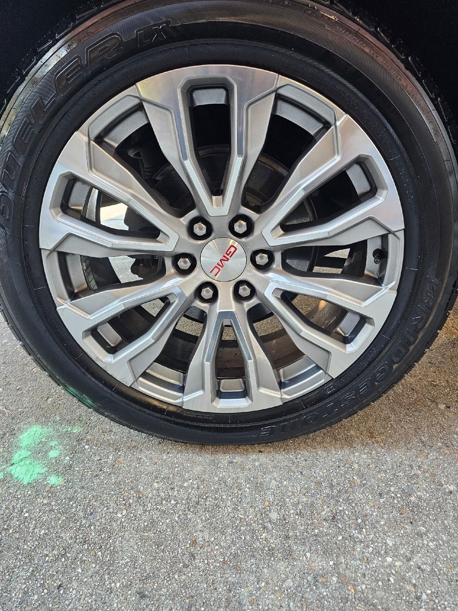Silver car wheel with TRD logo. Black tire, gray rim with geometric design.