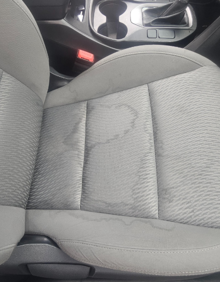 Light grey car seat with water stains.