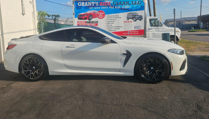 White BMW coupe parked in front of a car wash.