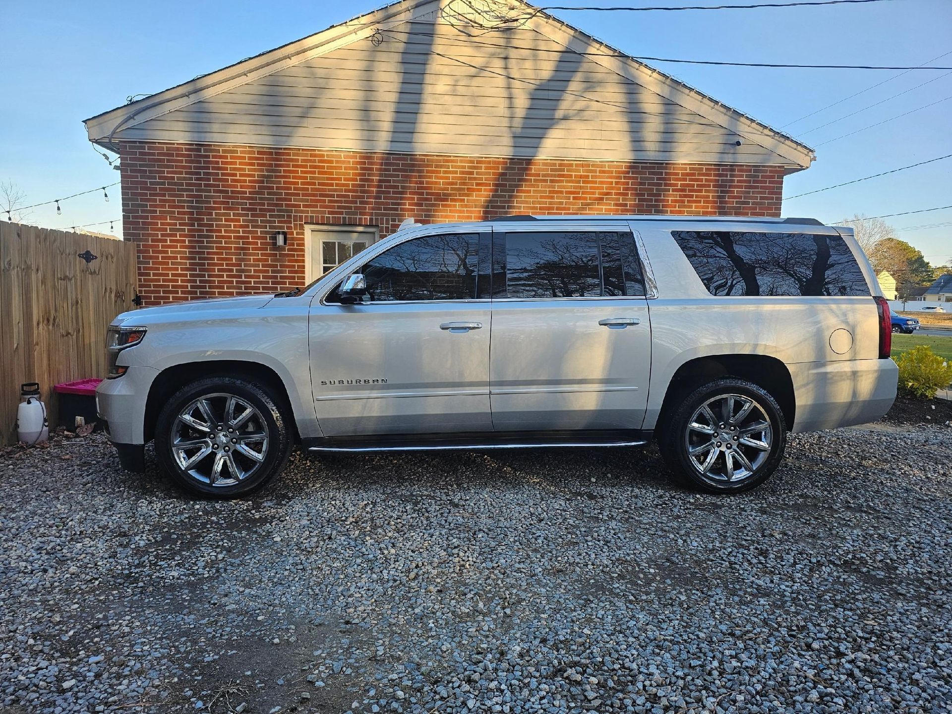Silver SUV parked on gravel in front of a brick building.