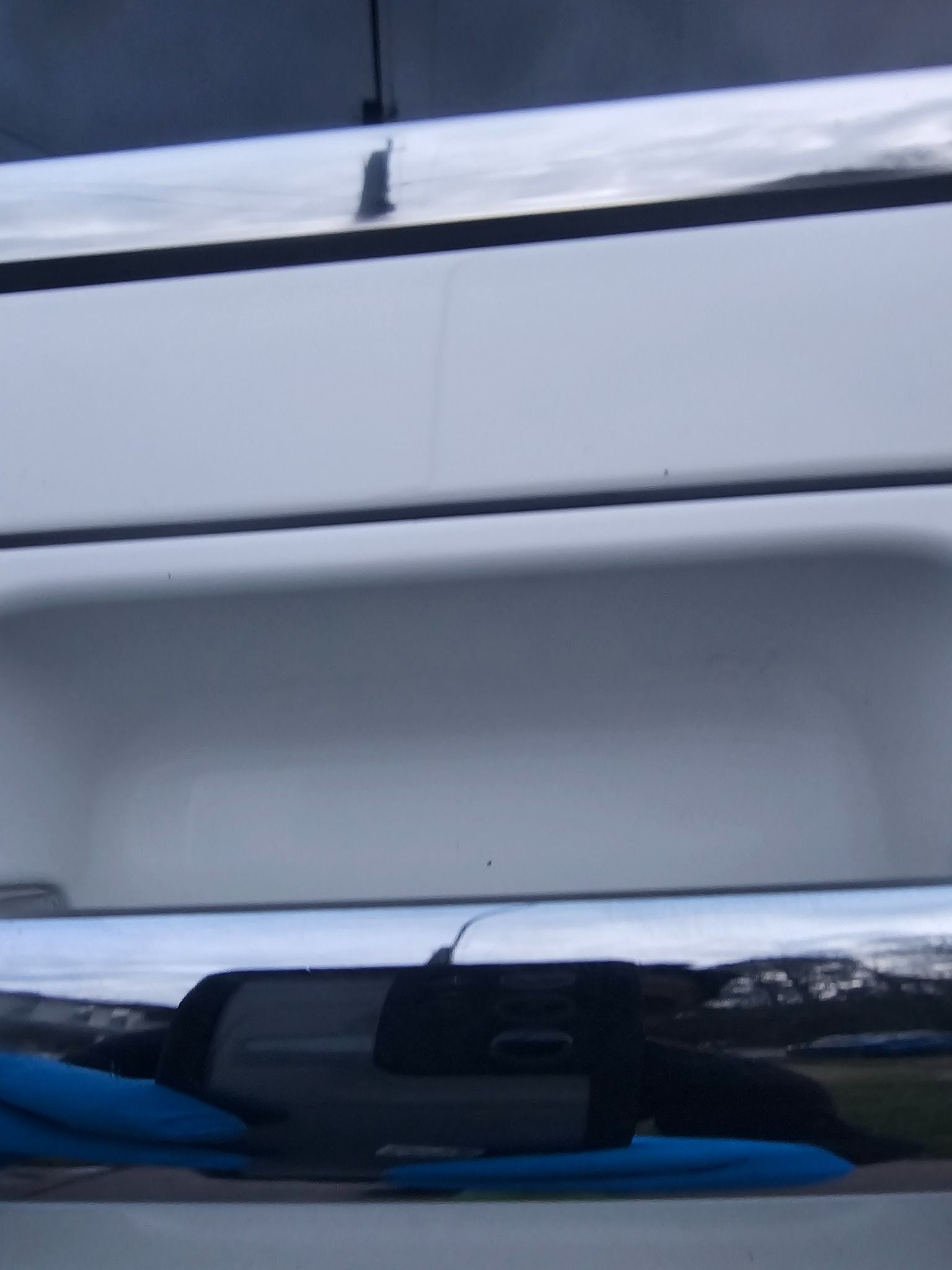 White vehicle with chrome accents reflecting surroundings; dark sky.