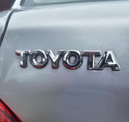 Chrome Toyota emblem on a silver car.