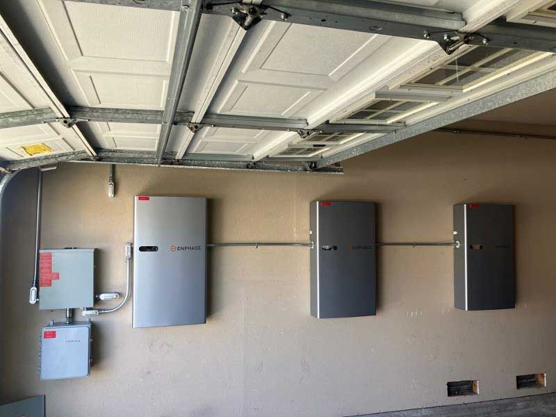 A garage with a garage door open and a bunch of boxes on the wall.